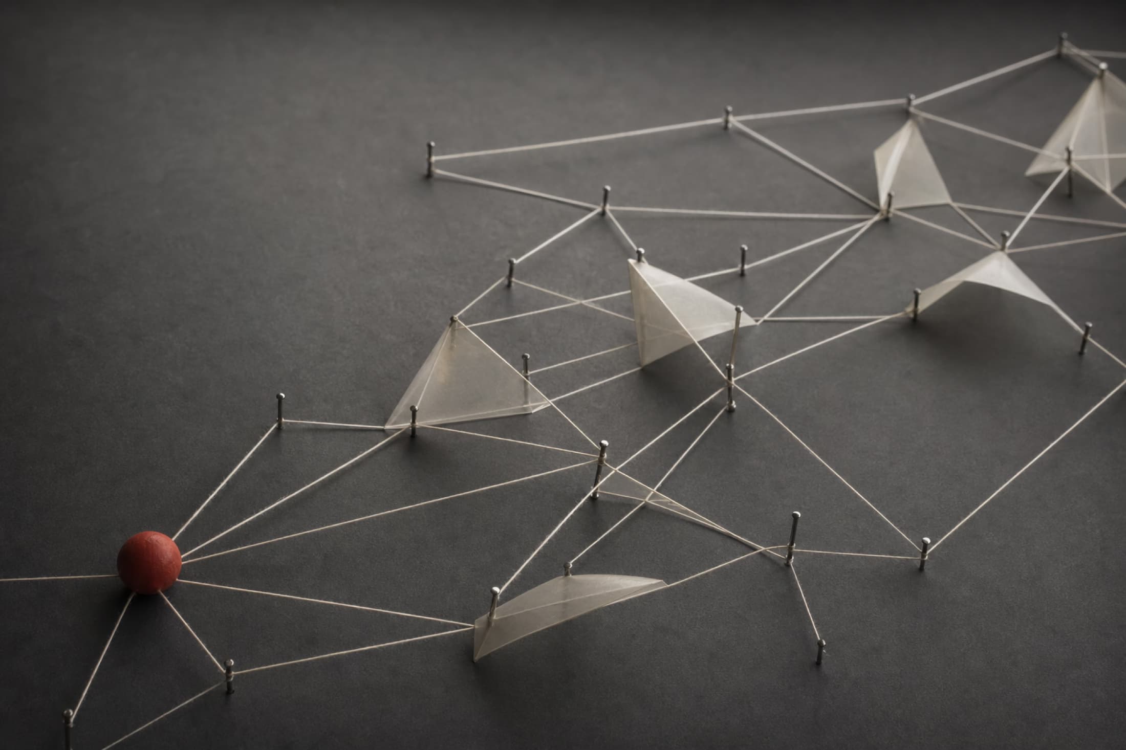 Abstraktes Fadennetz mit Papierflächen und einem roten Holzelement